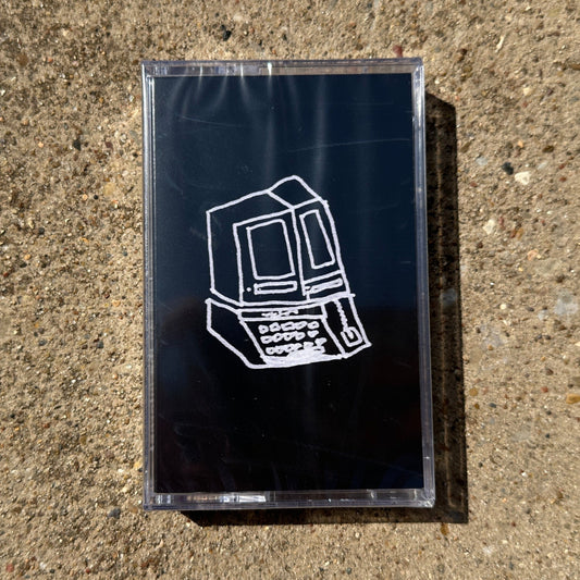 Black cassette tape with a white vintage computer design on a concrete surface